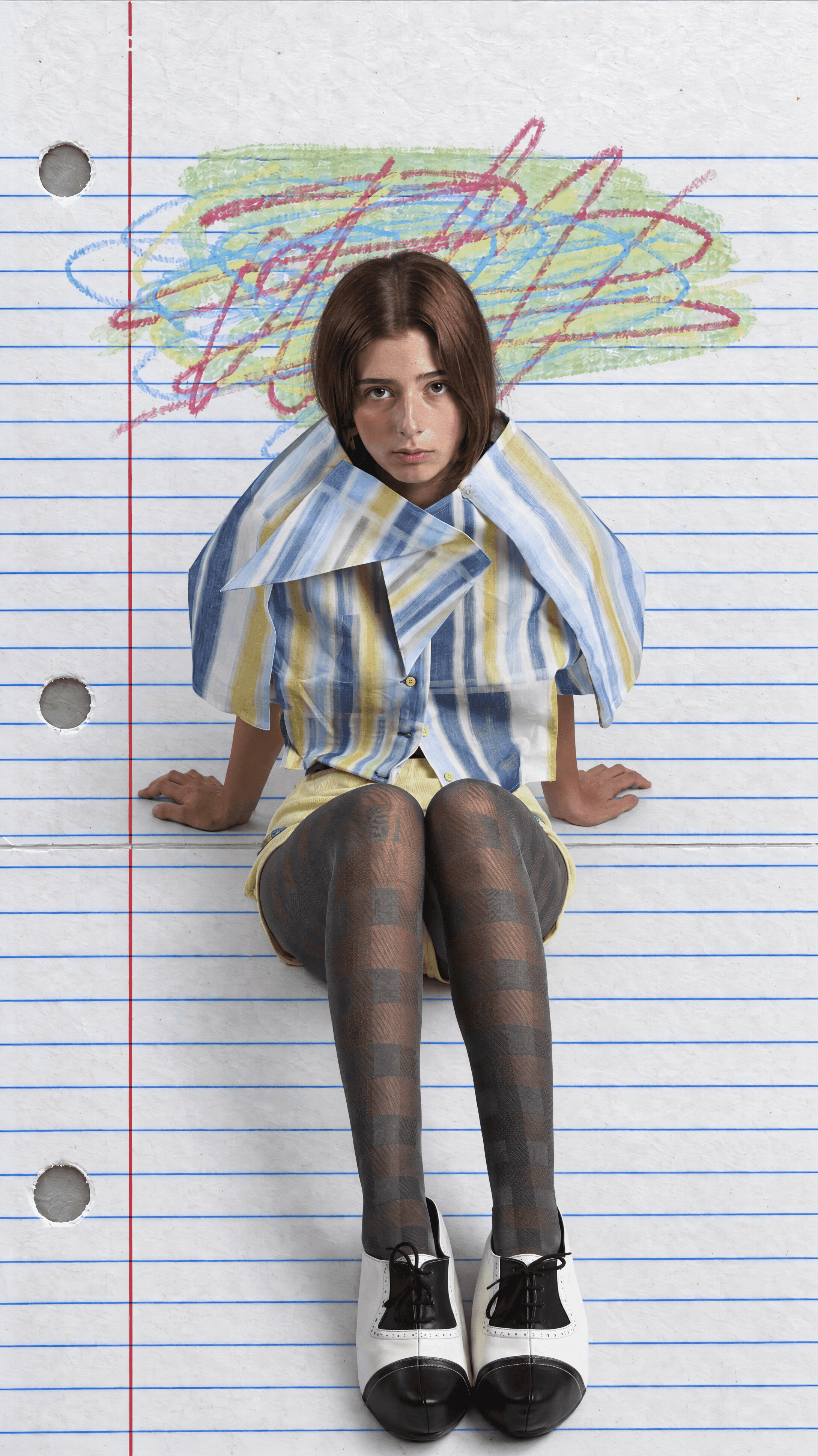 Model seated on lined notebook paper under a crayon scribble, wearing an oversized pointed-collar blue and yellow striped shirt, check tights and two-tone shoes